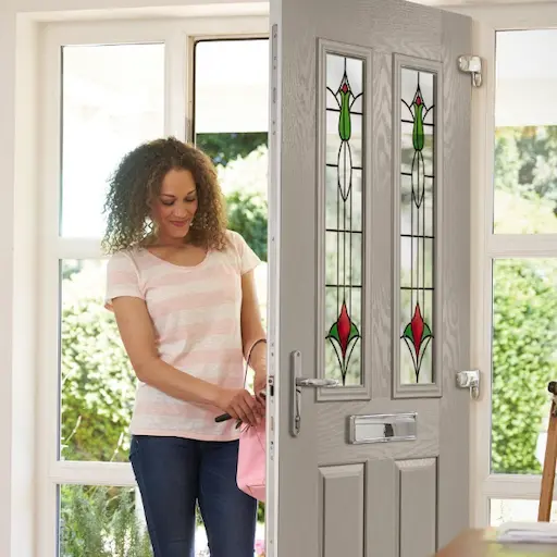 Photo of a womman opening a white wooden door into a house